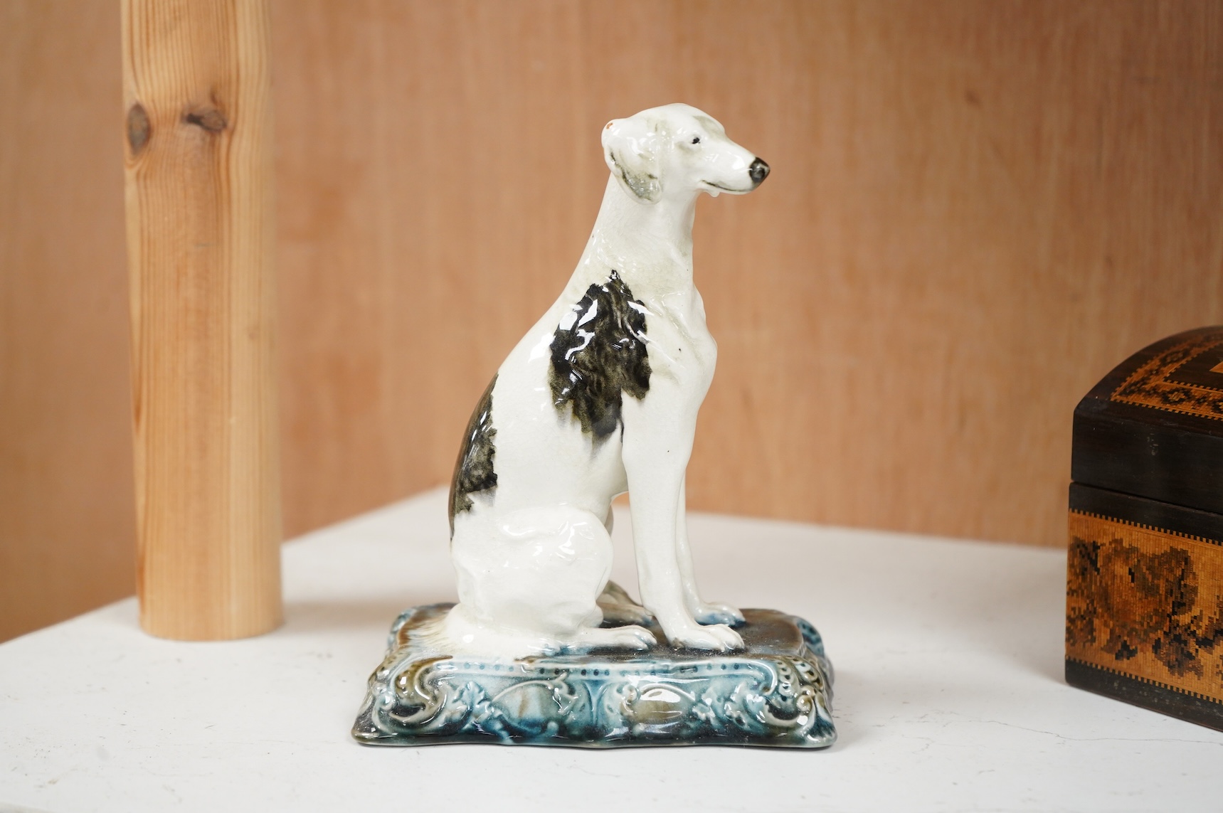 A Minton’s glazed pottery model of a seated Saluki, c.1905, stamped to the base, 15cm high